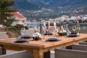 Una mesa de madera con platos y copas de vino encima. en Villa Bali with Private Pool, en Balíon