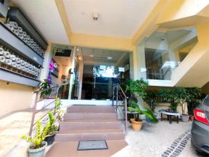 a house with stairs and plants in front of it at Sulit Hotel Manila in Manila