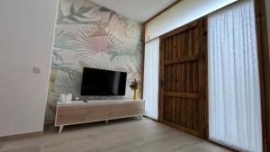 Una sala de estar con un televisor de pantalla plana en una pared. en Salabert Suite, en Valencia