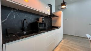 Una cocina con gabinetes blancos y una encimera negra. en Salabert Suite, en Valencia