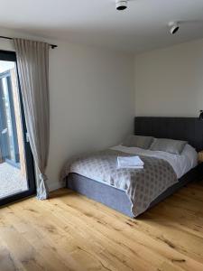 a bedroom with a bed and a large window at Zielono Mi! Dom przy Puszczy Kampinoskiej in Grądy