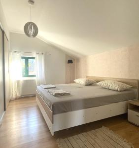 スタリー・グラードにあるApartman Neriumの大きなベッドと窓のある寝室