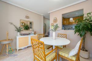 a dining room with a white table and chairs at Beach & City Center Apartment Campello in El Campello