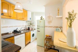 a kitchen with a refrigerator and a table at Beach & City Center Apartment Campello in El Campello