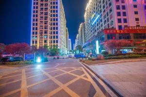 een lege straat 's nachts met hoge gebouwen bij 张家界博亭安屿设计师民宿 in Zhangjiajie