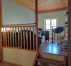 a living room with a wooden ceiling and a staircase at Les Lodges Du Pavillon F2 in Molinges