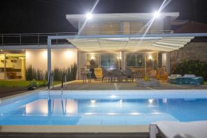 una piscina frente a una casa por la noche en Roque Village by Gerês Casas, en Vieira do Minho