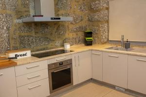 Una cocina con gabinetes blancos y un fregadero. en Roque Village by Gerês Casas, en Vieira do Minho 35 fotos más