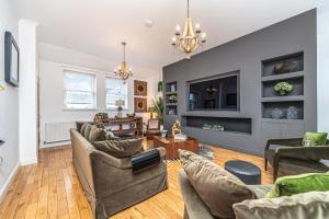 a living room with couches and a tv at Caledonia House- Luxurious Sea View House Near Edinburgh by Urban Haggis Stays in Fife