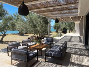 a patio with couches and a table and chairs at VILLA PORT OLIVIER in Alyfantá