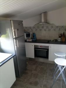 a small kitchen with a refrigerator and a microwave at Les grandes pouges in Saint-Avit-Saint-Nazaire