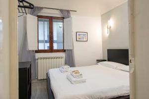 a bedroom with a white bed and a window at Il Vagello B&B in Florence