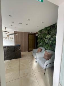 a lobby with two chairs and a plant at Tuck Inn in Larnaca