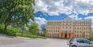 un bâtiment avec une voiture garée devant lui dans l'établissement Hotel Ilan, à Lublin