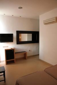 Pokój z łóżkiem i lustrem na ścianie w obiekcie Hostal Plaza Ruiz w mieście Ceuta