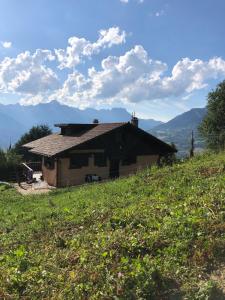 a house on the side of a hill in a field at Chalet LA TOUPINE centre St Gervais in Saint-Gervais-les-Bains