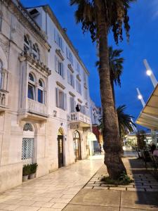 un edificio con una palma di fronte di Riva Luxury Suites a Spalato (Split)