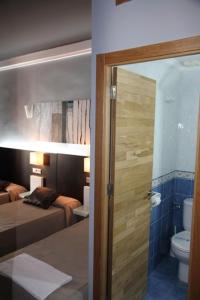 łazienka z sypialnią z łóżkiem i toaletą w obiekcie Hostal Plaza Ruiz w mieście Ceuta