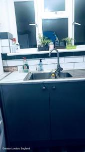 eine Küchentheke mit einem Waschbecken und einem Spiegel in der Unterkunft Private room in Hornchurch London Homestay in Hornchurch