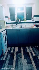 eine Küche mit Spüle und Waschmaschine in der Unterkunft Private room in Hornchurch London Homestay in Hornchurch