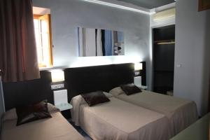 pokój hotelowy z dwoma łóżkami i oknem w obiekcie Hostal Plaza Ruiz w mieście Ceuta