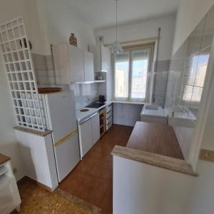 a kitchen with white cabinets and a white refrigerator at L' attichetto in Rome