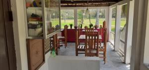 a dining room with a red table and chairs at Arachiwil Green Nature Resort in Puttalam