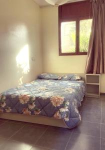 a bedroom with a bed and a window at residence rose des sables in Dakhla