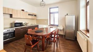 a kitchen with a table and chairs and a refrigerator at Apartmán na Krajzontě in Polná