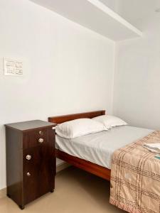 a small bedroom with a bed and a nightstand at Cozy Haven Homestay Fort Kochi in Cochin
