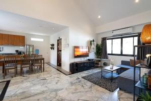 ein Wohnzimmer mit Couch und ein Esszimmer in der Unterkunft Family friendly villa in Phra Ae beach