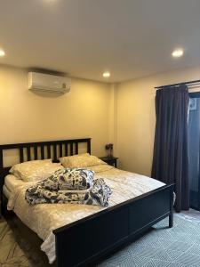 ein Schlafzimmer mit einem Bett mit einer Decke darauf in der Unterkunft Family friendly villa in Phra Ae beach