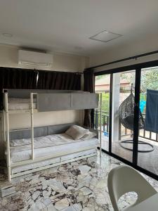 1 Schlafzimmer mit 2 Etagenbetten und einem Balkon in der Unterkunft Family friendly villa in Phra Ae beach + 13 Fotos