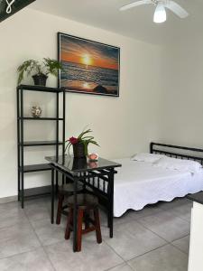 a bedroom with a bed and a table and a bed at Chalé Orquidea in São Sebastião