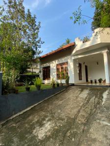 a house with a driveway in front of it at Dili's Homestay - Private Villa in Kandy