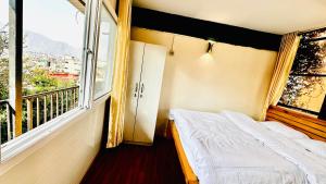a bedroom with a bed and a large window at Institute Of Natural Medicine , Yoga & Therapy home in Kathmandu +100 photos