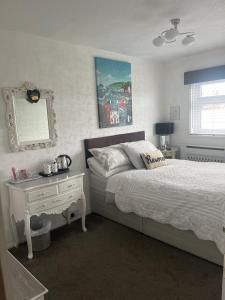 a bedroom with a bed and a table and a mirror at Southend Airport Bed & Breakfast in Rochford