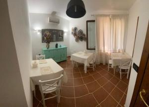 a dining room with white tables and white chairs at Domo Rosada in Ottava Sassari