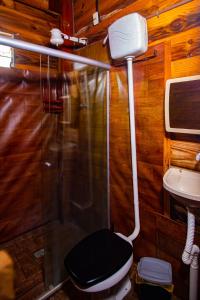 a bathroom with a shower and a toilet and a sink at Mística Suítes in São Thomé das Letras +20 photos