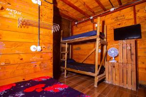 a bedroom with two bunk beds in a log cabin at Mística Suítes in São Thomé das Letras