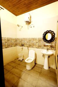 un baño con inodoro y lavabo en Hari Mahal Resort, en Behror