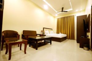 Una habitación de hotel con una cama, una mesa y sillas. en Hari Mahal Resort, en Behror