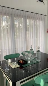 a glass table with a green chair in front of a window at Asaan homestay in Ciburial +8 photos