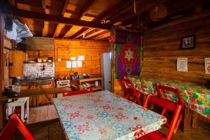 a dining room with a table and chairs and a kitchen at Mística Suítes in São Thomé das Letras