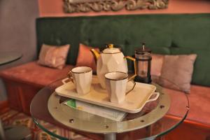 a glass table with two coffee cups on it at Senora Ines Hotel Boutique in Buga