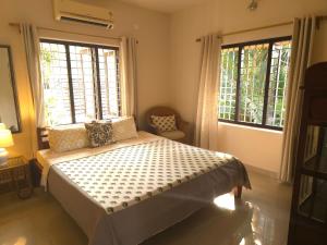 阿勒皮Bella Homestay Kerala的一间卧室设有一张床和两个大窗户