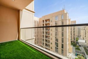 1BR Apartment With Balcony - 9 Mins to Sharjah Airport - Balcony Breeze في الشارقة: بلكونه مطله على مبنى كبير
