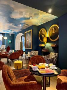 ein Wohnzimmer mit Stühlen und einem Tisch mit Essen darauf in der Unterkunft Hotel Divino by Fimedhotels in Figueres