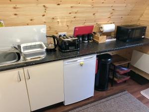 a kitchen with a counter with a sink and a refrigerator at Breakish Bay Pods in Breakish