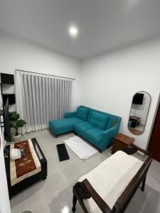 a living room with a blue couch in a room at Asaan homestay in Ciburial